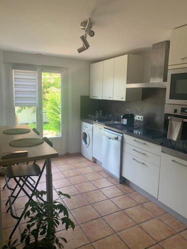 - une cuisine avec des appareils électroménagers blancs et une table dans l'établissement Magnifique T1 entre mer et montagne, à Ascain