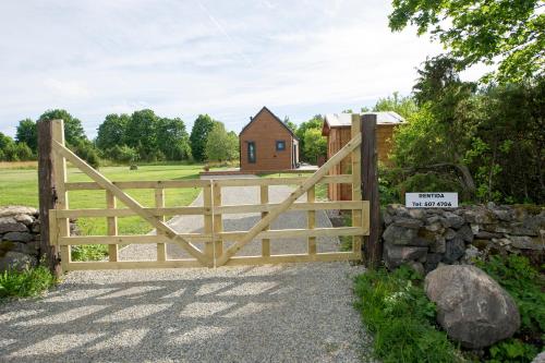a wooden gate with a house in the background at Muhu Kupja suvemaja UUS in Liiva