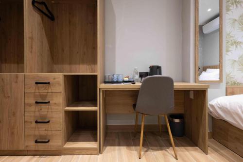 a bedroom with a desk and a bed and a chair at University Boutique Rooms in Msida