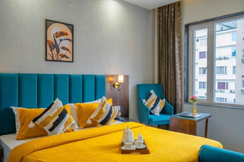 Pokój hotelowy z żółtym łóżkiem i niebieskim krzesłem w obiekcie Perfectstayz Premium Laxmi Heritage with Rooftop Pool & Cafe w mieście Rishikesh