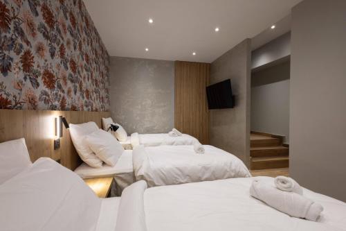 a hotel room with two beds and a television at University Boutique Rooms in Msida