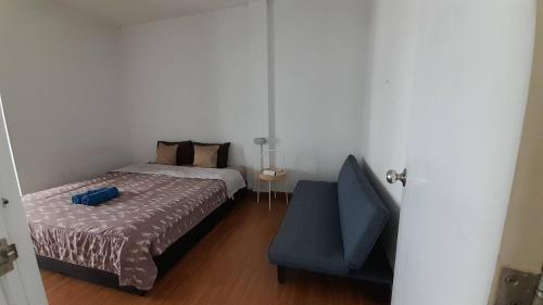 a bedroom with a bed and a blue chair at HOMEY-Sleepy Don Mueang Airport Hostel in Bangkok