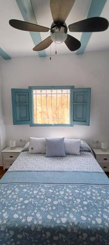 a bedroom with a bed with a ceiling fan at Ca la Yaya in Lliria