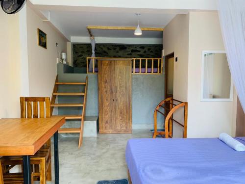 a room with a bed and a table and a ladder at Happy Sky Ella in Ella