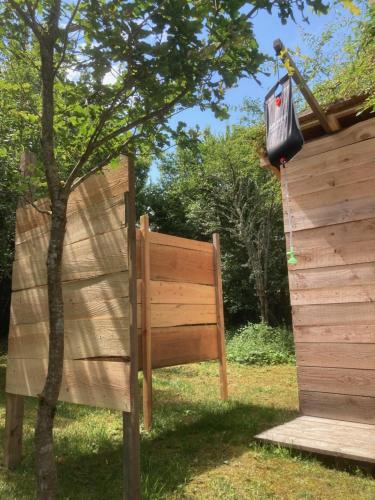 a bench next to a fence with a bag hanging from it at Le jardin secret in Semur-en-Auxois