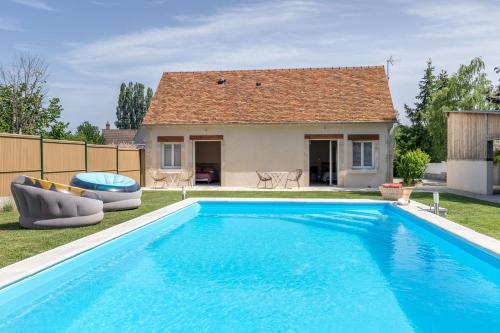 een groot blauw zwembad voor een huis bij Le gîte L'As de Seur in Seur