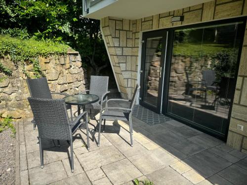 a patio with chairs and a table and glass doors at Apartmán Komenského 14 in Prievidza