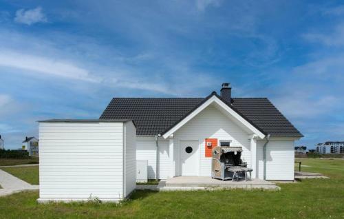 a small white house with a garage at Happy Holidays in Olpenitz