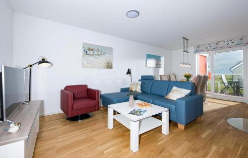 a living room with a blue couch and a red chair at Happy Holidays in Olpenitz