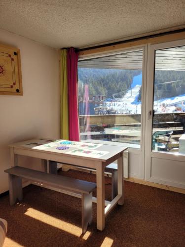 une pièce avec une table et une fenêtre avec vue dans l'établissement LE LIORAN appartement vue face à la montagne au pied des pistes, à Laveissière
