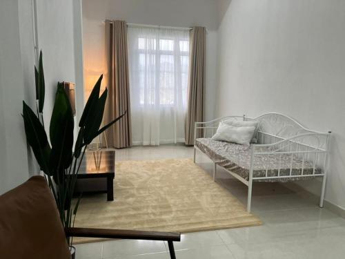 a white living room with a couch and a table at Nick Cozy Homestay 1st Floor in Jeli