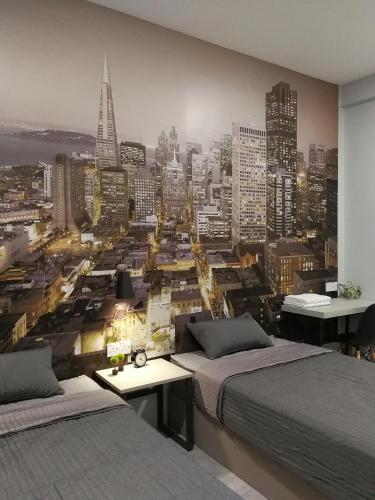 a bedroom with two beds and a view of a city at Check-Inn Guesthouse in Ipoh