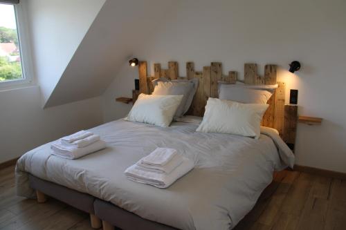 a bedroom with a bed with towels on it at Appart Centre Village in Condette