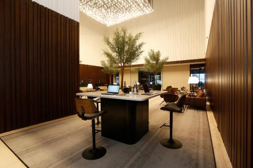 a lobby with a bar with chairs and a table at ALMA Hotel Riyadh in Riyadh