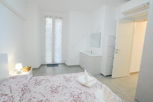 a white bedroom with a bed and a window at Sopra le Onde VADOALMARE Immobiliare in Vado Ligure