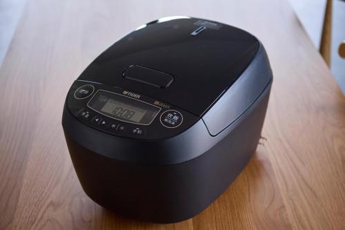 a black computer mouse sitting on a wooden table at Refwind in Kyonan