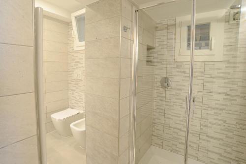 a white bathroom with a shower and a toilet at Sopra le Onde VADOALMARE Immobiliare in Vado Ligure