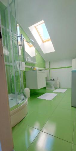 a large bathroom with green walls and a skylight at House Katarina in Rtina