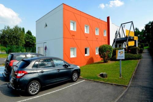 a car parked in a parking lot in front of a building at Premiere Classe Arras - Tilloy Les Mofflaine in Tilloy-lès-Mofflaines