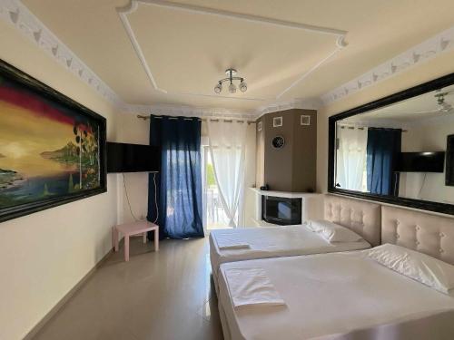 a bedroom with two beds and a large mirror at Apartments Alexandros in Polykhrono