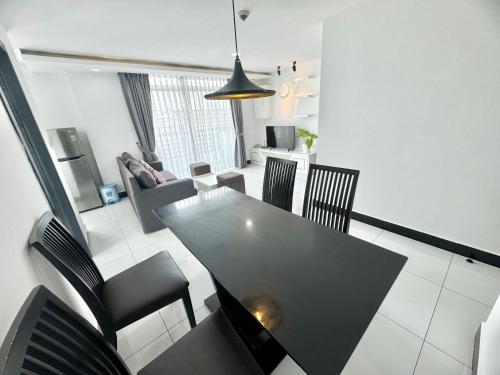 ein Esszimmer mit einem schwarzen Tisch und Stühlen in der Unterkunft PTH Residence in Phnom Penh