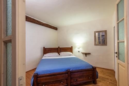 - une chambre avec un lit en bois et une couverture bleue dans l'établissement Appartamento nel cuore di Volterra, à Volterra