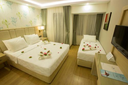 a hotel room with two beds with flowers on them at Sundia By Liberty Oludeniz in Oludeniz