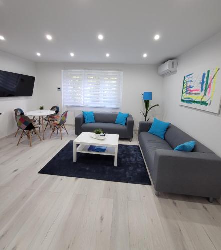 a living room with a couch and a table at Blue Apartman in Dunaújváros