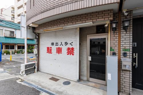 a garage door on a building with writing on it at 66 sixty-six in Osaka