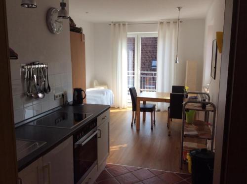 a kitchen with a sink and a table with a dining room at Haus am Herrenwall in Esens