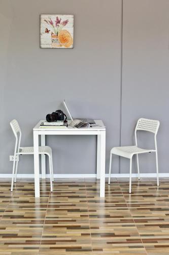 a white desk and two chairs in a room at Rangh Place in Ban Map Samet Daeng