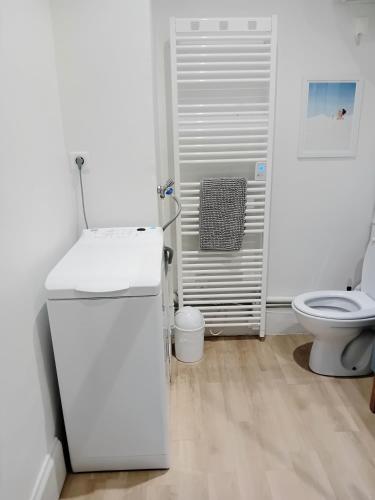 une salle de bain blanche avec des toilettes et un lavabo dans l'établissement Authentik Duguesclin -Lyon 3, à Lyon