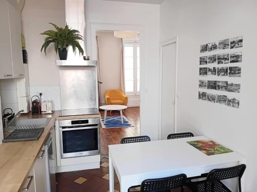 une cuisine avec une table blanche et des chaises dans l'établissement Authentik Duguesclin -Lyon 3, à Lyon