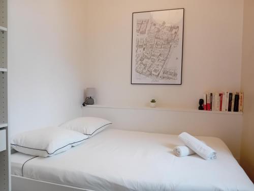 un lit blanc avec deux oreillers dessus dans l'établissement Authentik Duguesclin -Lyon 3, à Lyon