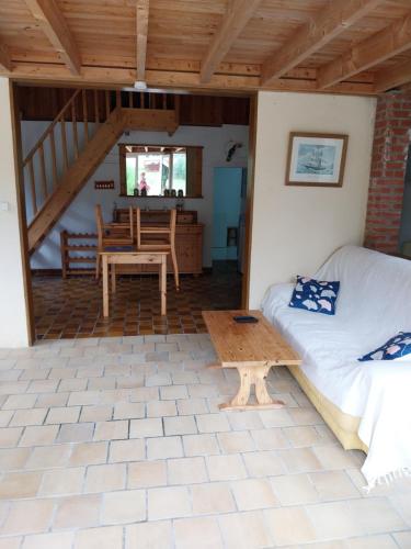 un salon avec un lit et une table dans l'établissement Maison proche de la Mer, à Barneville-Carteret