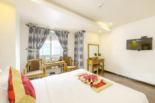 a bedroom with a bed and a desk and a table at The Airport Hotel in Ho Chi Minh City
