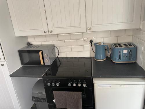 a kitchen with a counter top with a stove and a microwave at Beautiful 2 bedroom property with 5G WI-FI in Hull