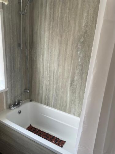 a bathroom with a tub with a shower at Beautiful 2 bedroom property with 5G WI-FI in Hull