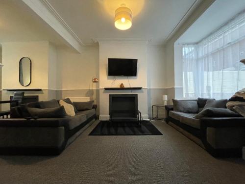 a living room with two couches and a fireplace at Beautiful 2 bedroom property with 5G WI-FI in Hull