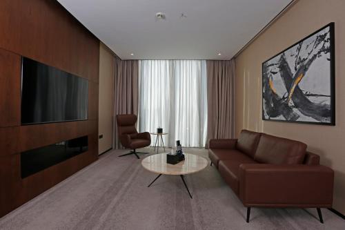 a living room with a couch and a television at ALMA Hotel Riyadh in Riyadh
