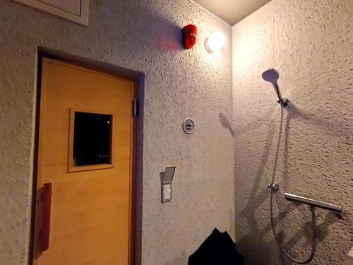 a room with a door and a hair dryer on the wall at Refwind in Kyonan