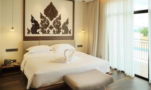 a hotel room with a bed with swans on it at MonMonBoutique Hotel in Thakho