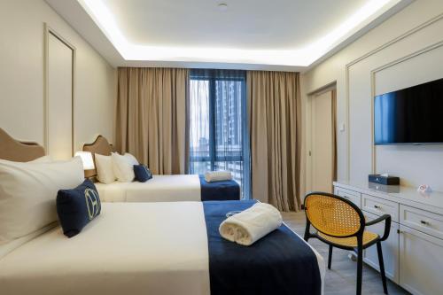 a hotel room with two beds and a television at The Host Hotel in Ipoh