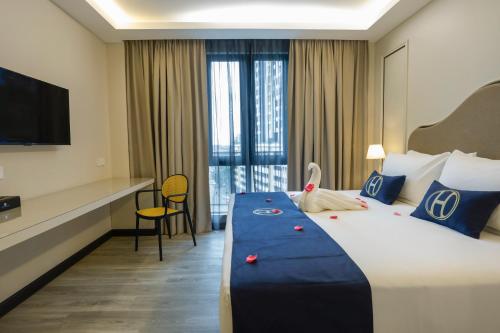 a hotel room with a large bed and a television at The Host Hotel in Ipoh
