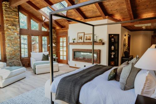 a bedroom with a large bed and a fireplace at Stone House by Casa Oso, hot tub, 43 private acres with hiking trails in Mariposa