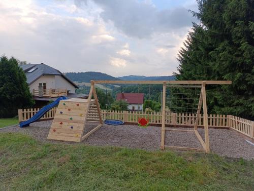 a playground with a slide and a swing set at Sowi Gościniec Wellness & Breakfast in Sokolec
