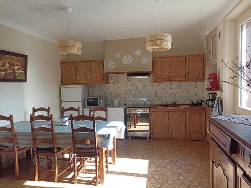 une cuisine avec une table et des chaises dans une cuisine dans l'établissement Maison de campagne Lot/Dordogne, à Rouffilhac