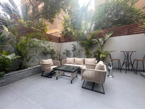 a patio with a couch and chairs and a table at Lacasa Residence in Cairo