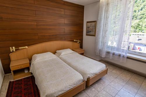 a small bedroom with a bed and a window at Albergo Stazione in Bodio