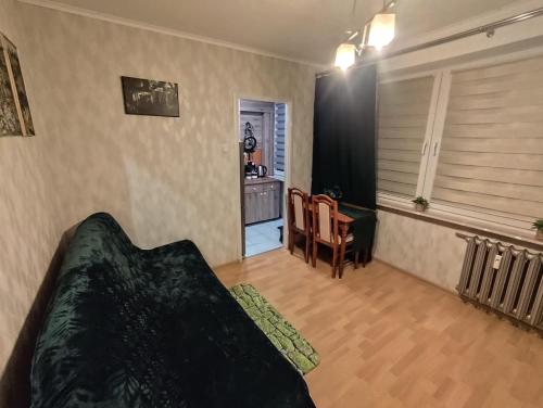 a bedroom with a bed and a table and a chair at Mroczne marzenie in Przemyśl